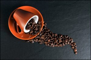 cup with spilled coffee beans